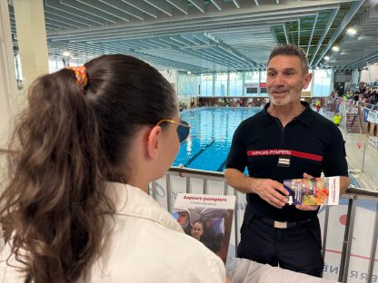 Sapeur-pompier du SDIS 31 qui présente le volontariat à une jeune fille lors du challenge Oxyjeunes à la piscine Léo Lagrange